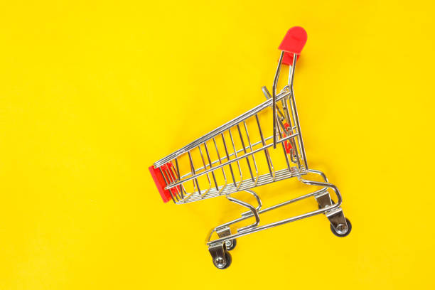 istock red shopping cart top view on yellow background. 1142800943