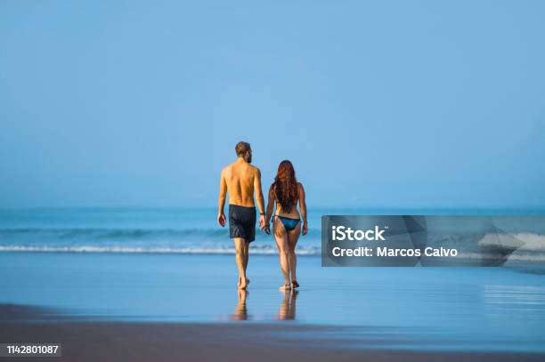 Young Happy And Beautiful Couple Enjoying Summer Holidays Travel Or Honeymoon Trip Together In Tropical Paradise Beach Having Fun Walking Relaxed And Playful On The Sea Smiling Cheerful Stock Photo - Download Image Now