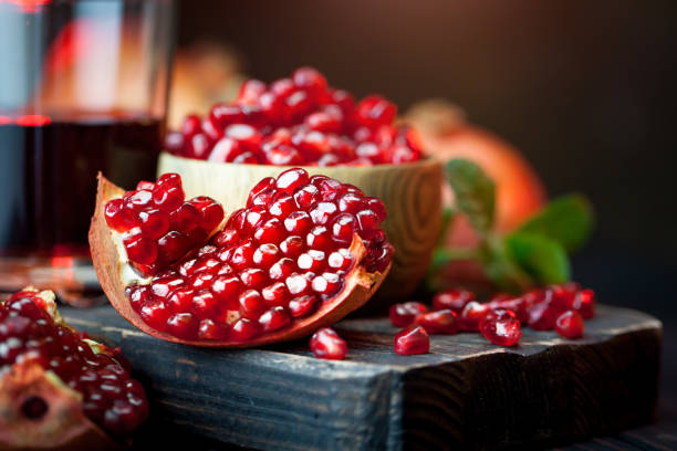 Ripe pomegranate fruit on a old black wooden vintage background. Selective focus. Ripe pomegranate fruit on a old black wooden vintage background. Horizontal. Selective focus. pomegranate stock pictures, royalty-free photos & images