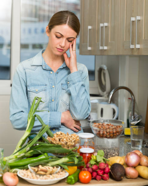 istock Woman suffering from headache at kitchen 1142802196