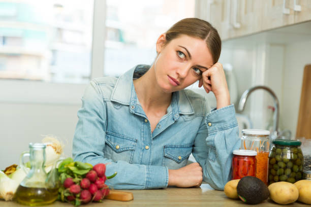 istock Tired woman sitting at home kitchen 1142802220