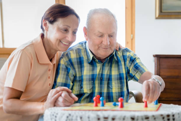 istock Caregiver and senior man playing board game 1142802277