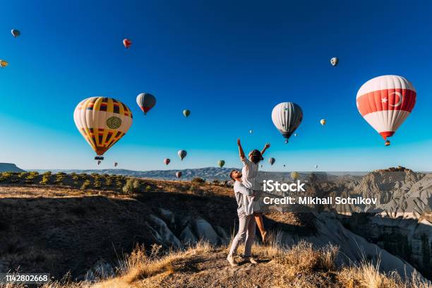 Wedding Travel Honeymoon Trip Couple In Love Among Balloons A Guy Proposes To A Girl Couple In Love In Cappadocia Couple In Turkey Man And Woman Traveling Flying On Balloons Tourists Stock Photo - Download Image Now