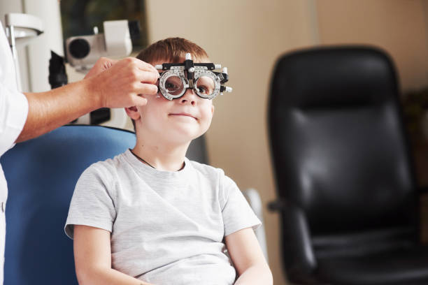 istock Checking different lenses. Child sitting in the doctor's cabinet and have tested his visual acuity 1142802800