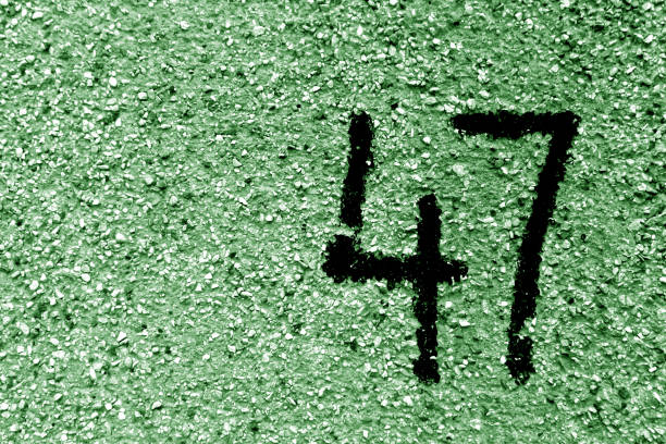 istock Number 47 on cement wall in stencil in green tone 1142805591