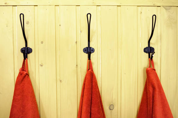 istock three red towels on hangers on yellow wooden wall 1142805847