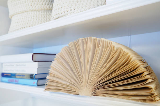 istock open book with pages lying on white bookshelf 1142805858