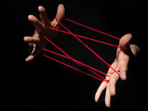 Playing cats cradle game.