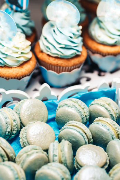 istock turquoise macaroons and muffins with meringue close-up on festive table. 1142807239