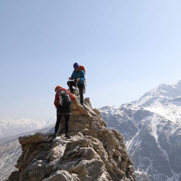 istock Mountaineers climb to mountain peak 1142807462