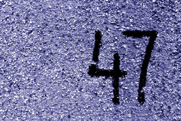 istock Number 47 on cement wall in stencil in blue tone. 1142808851