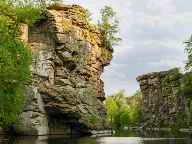 istock Overhanging rocks on two banks of the plain river 1142808880