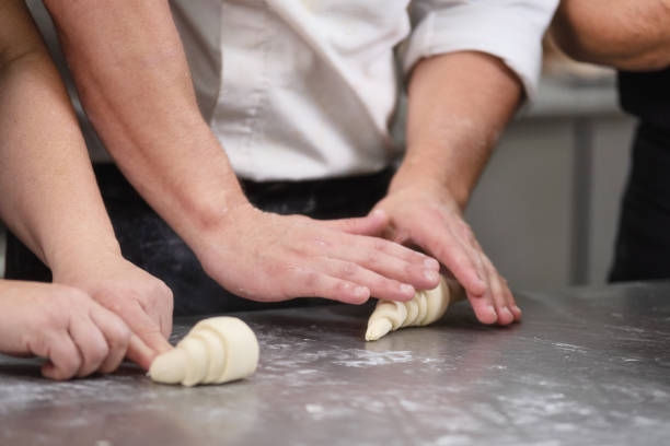 pastry chef rolling fresh raw croissant dough. - buns of steel imagens e fotografias de stock