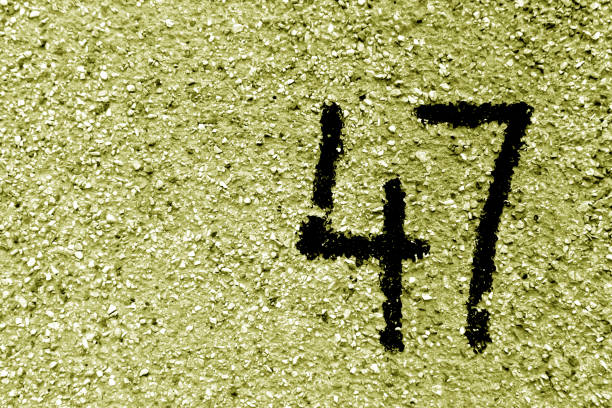istock Number 47 on cement wall in stencil in yellow tone 1142813584