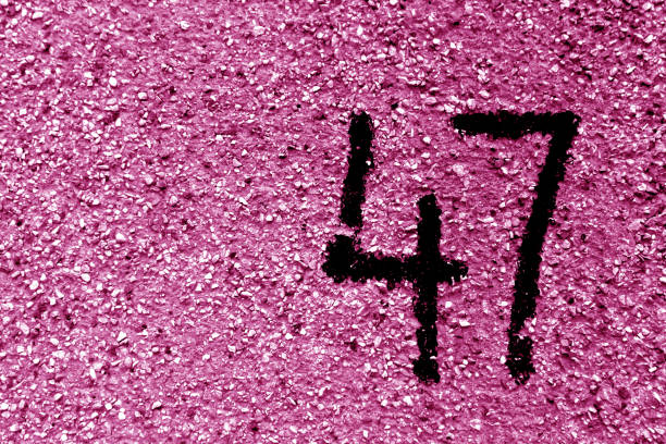 istock Number 47 on cement wall in stencil in pink tone 1142814254