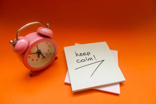 istock Keep Calm - Alarm Clock And Adhesive Note Over Orange Background 1142814283