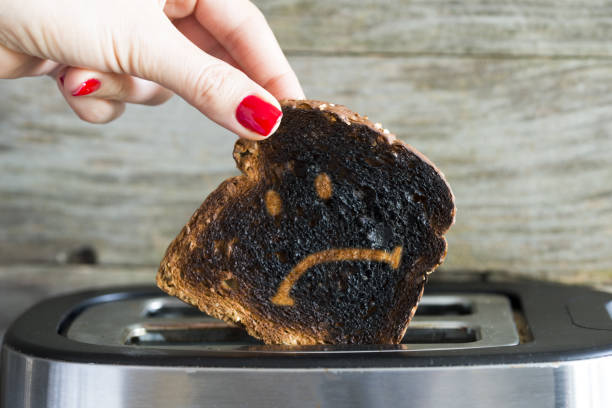 istock Sad face on slice of burned toast bread 1142815809