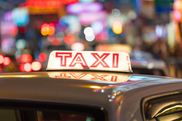 close-up de signe de taxi avec la lumière la nuit dans la zone commerçante, hong kong, chine - hong shopping night skyline photos et images de collection