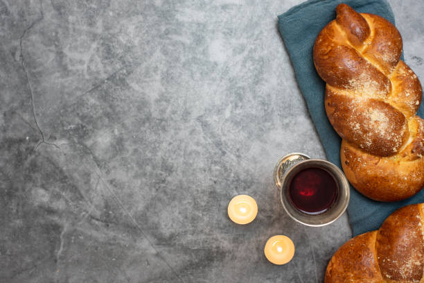 shabbat shalom-pain challah, vin de shabbat et bougies sur fond gris. vue de dessus. avec espace de copie - challah jewish sabbath photography candle photos et images de collection