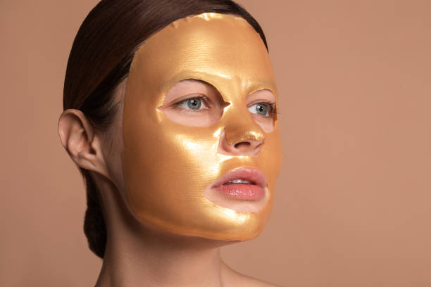 istock Woman using shiny sheet mask and looking away 1142821437