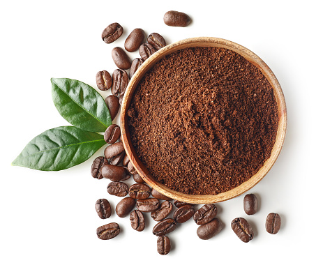 Bowl of ground coffee and beans isolated on white background, top view