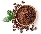 Bowl of ground coffee and beans isolated on white background