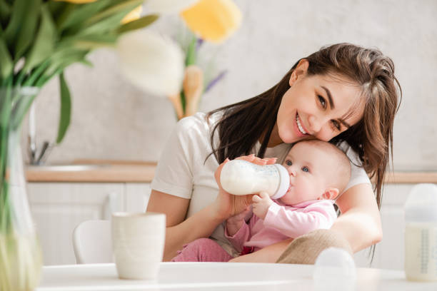 istock Woman feeding newborn with formula in a bottle. 1142823239