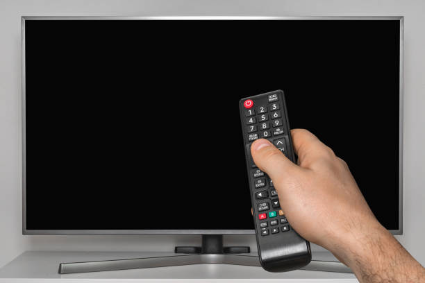 istock Black screen on TV and human hand with TV remote control 1142824950