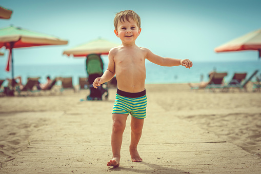 Cute happy child enjoying beach holidays in summer