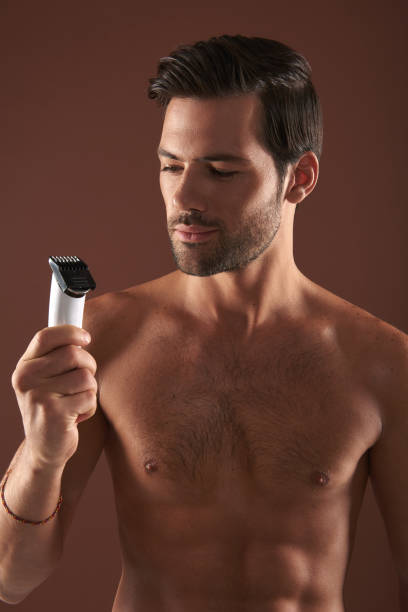 istock Handsome young man looking at razor in hand 1142825585