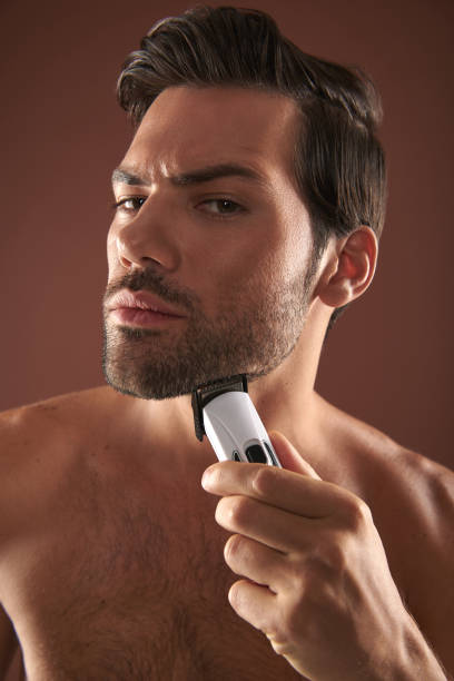istock Manful young guy focusing on shaving himself 1142825615