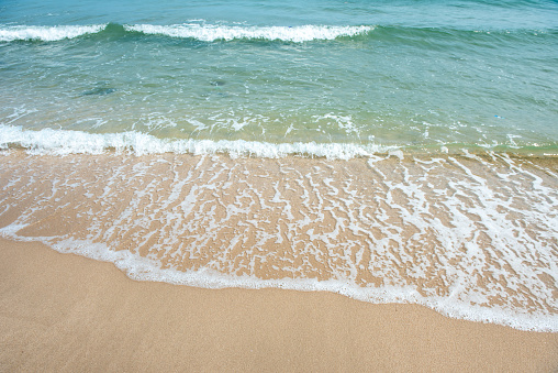 Beach waves of the sea on the sandy beach season Summer on top view background .
