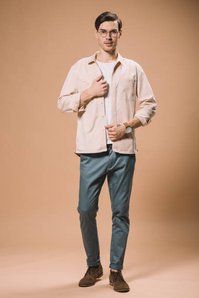 istock handsome man with watch on hand standing on beige background 1142827745