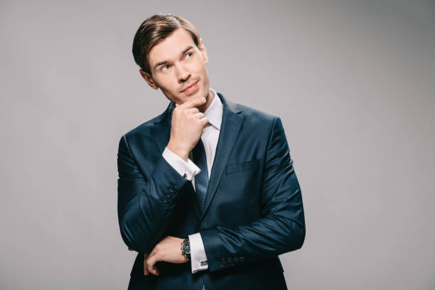 istock pensive businessman in suit thinking on grey background 1142827928