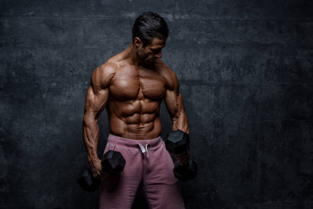 istock Muscular Men Lifting Weights. Performing Dumbbel Biceps Curls 1142828206