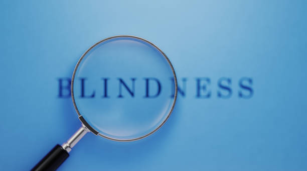 istock Vision And Blindness Concept - Magnifier And Blindness Text On Blue Background 1142828739
