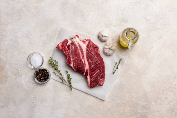 Fresh beef meat on white background with olive oil, herbs and spices