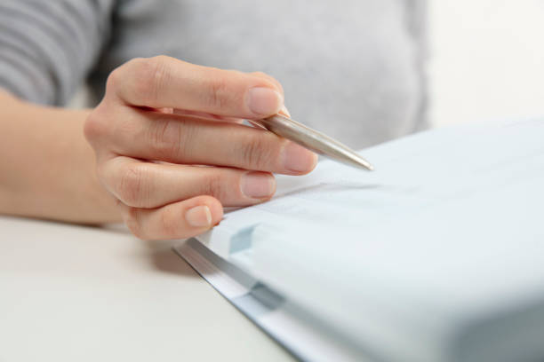 istock Woman reading, pen showing text in a book 1142830789