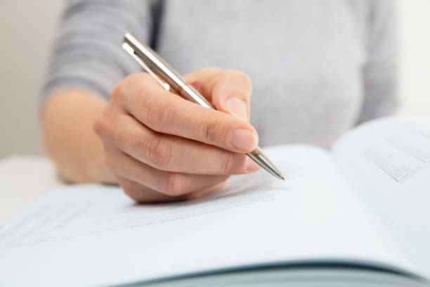 istock Woman reading, pen showing text in a book 1142831045