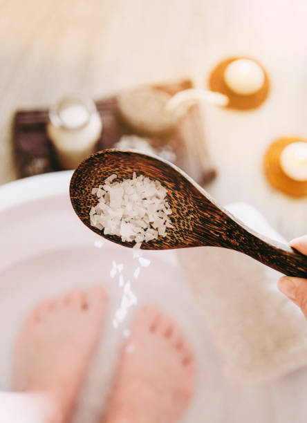 istock Adding Magnesium Chloride vitamin salt in foot bath water, solution. Magnesium grains in foot bath water are ideal for replenishing the body with this essential mineral, promoting overall wellbeing. 1142834695