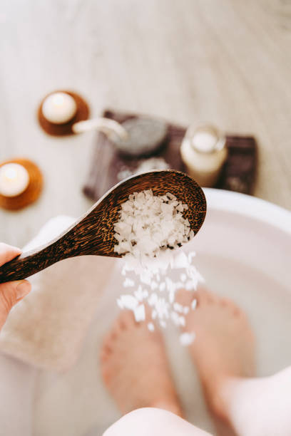 istock Adding Magnesium Chloride vitamin salt in foot bath water, solution. Magnesium grains in foot bath water are ideal for replenishing the body with this essential mineral, promoting overall wellbeing. 1142834699