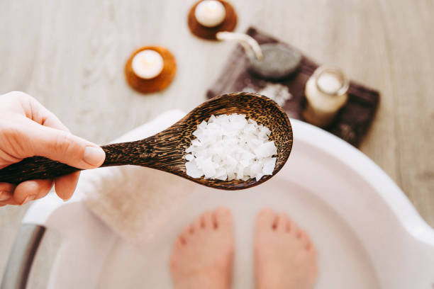 fügen sie magnesium chlorid vitaminsalz in fußbad wasser, lösung. magnesiumkörner im fußbad sind ideal, um den körper mit diesem essentiellen mineral aufzufüllen und so das allgemeine wohlbefinden zu fördern. - soaking tub stock-fotos und bilder