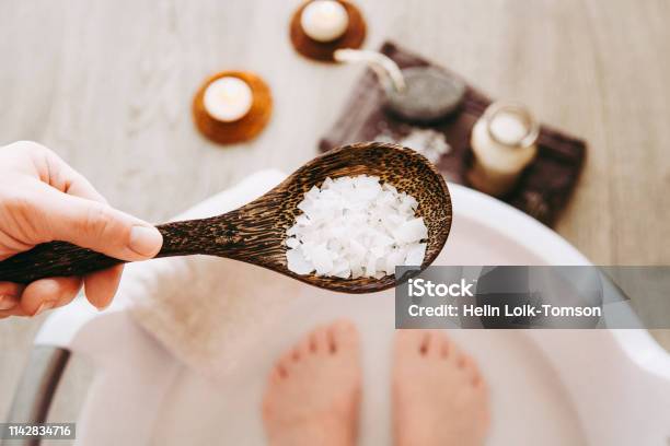 발 목욕 물에 염화 마그네슘 비타민 염을 추가 솔루션 발 목욕 물에 들어 있는 마그네슘 곡물은이 필수 미네랄로 신체를 보충 하 고 전반적인 웰빙을 촉진 하는 데 이상적입니다 족욕에 대한 스톡 사진 및 기타 이미지
