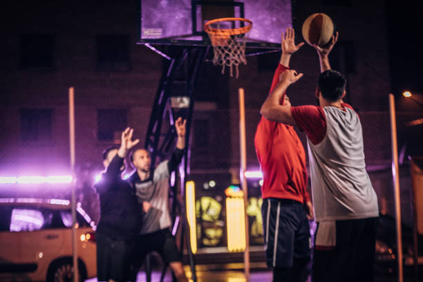 istock Men playing basketball outdoors at night 1142836812