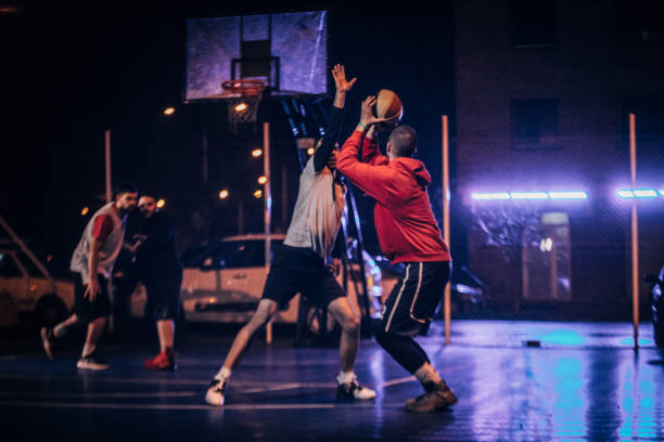 istock Men playing basketball at night 1142836840