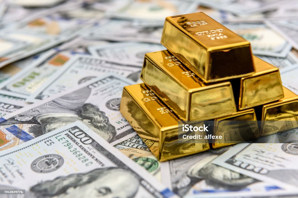 Gold bullion on american dollar banknotes close up Gold - Metal Stock Photo