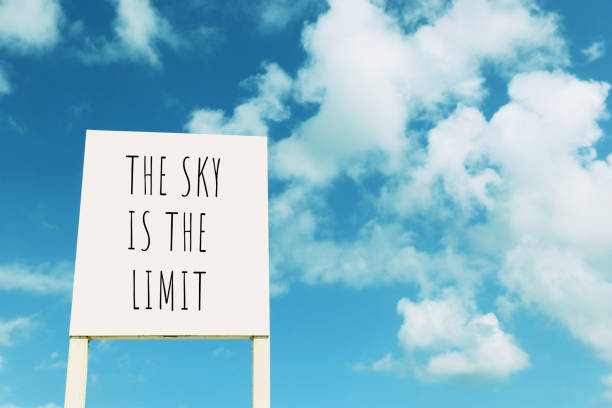 signe contre le ciel bleu avec des nuages avec le texte â le ciel est la limite - action sign motivation initiative photos et images de collection