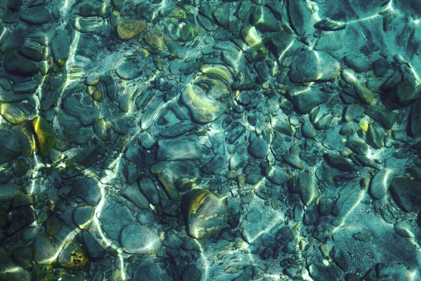 Beautiful shining pebbles under clear turquoise water Beautiful shining colorful pebbles under clear turquoise water, background or texture crystal clear water lake stock pictures, royalty-free photos & images