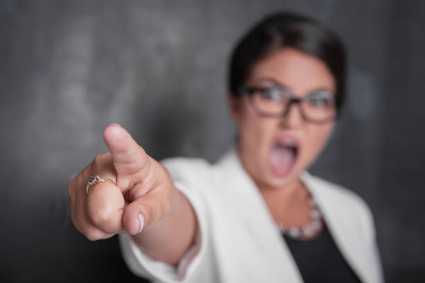 Angry screaming woman pointing out. Focus on hand stock photo