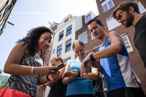 grupo de equipe sportive dos corredores na cidade de amsterdão - checking the time fotos - fotografias e filmes do acervo